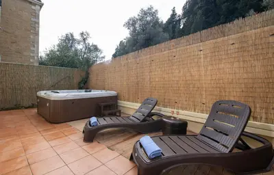 two chairs and a hot tub on a patio at Jacuzzi Villa Nena in Thérison