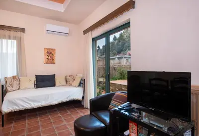 a living room with a couch and a tv at Jacuzzi Villa Nena in Thérison