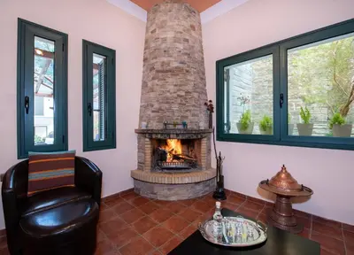 a living room with a fireplace and a chair at Jacuzzi Villa Nena in Thérison