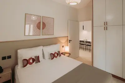 a bedroom with a white bed with two pillows at Cozy Living Apartments Chania close to the beach in Chania Town