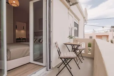 a balcony with a table and chairs and a bedroom at Cozy Living Apartments Chania close to the beach in Chania Town