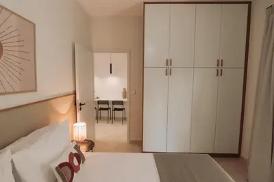 a bedroom with a bed and a white cabinet at Cozy Living Apartments Chania close to the beach in Chania Town