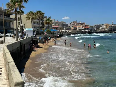 a group of people swimming in the ocean on a beach at The Sandgate Elegant studio, Chania Seaside in Chania Town