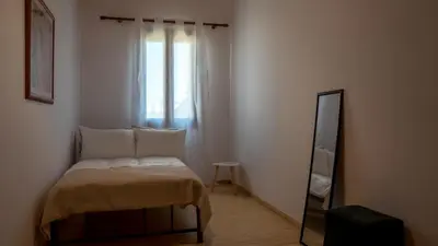 a small bedroom with a bed and a mirror at Τhemis House in Chania Town