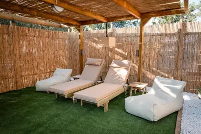 a patio with two chairs and a pergola at Falasarna Caravans in Falasarna