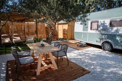 a wooden table and chairs and an rv parked at Falasarna Caravans in Falasarna