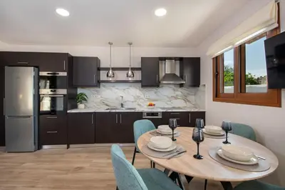 a kitchen and dining room with a wooden table and chairs at Iasmos in Sfakiá