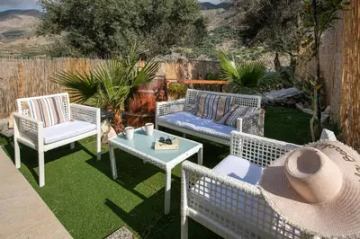 a patio with three wicker chairs and a table at Iasmos in Sfakiá