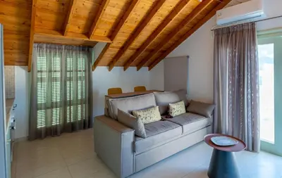 a living room with a couch and wooden ceilings at Paleochora Central Apartments in Palaiochóra