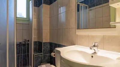a bathroom with a sink and a shower at Paleochora Central Apartments in Palaiochóra