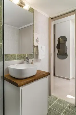 a bathroom with a white sink and a mirror at SugarDustApt Elegant Retreat 150m from the Sea in Chania Town