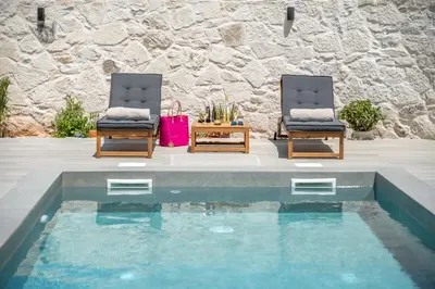 two chairs and a table next to a swimming pool at Murelos in Chania Town