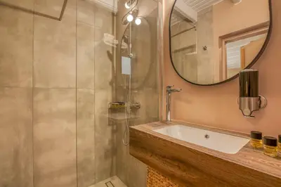 a bathroom with a tub and a shower with a mirror at Murelos in Chania Town