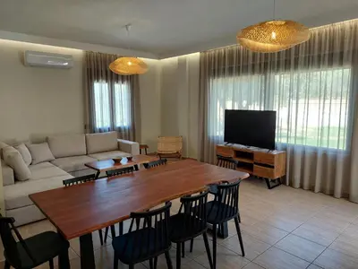 a living room with a couch and a table and chairs at VENTO villa neriana in Khainderianá