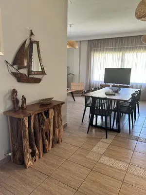 a dining room with a table and a table and chairs at VENTO villa neriana in Khainderianá