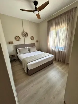 a bedroom with a bed and a ceiling fan at VENTO villa neriana in Khainderianá