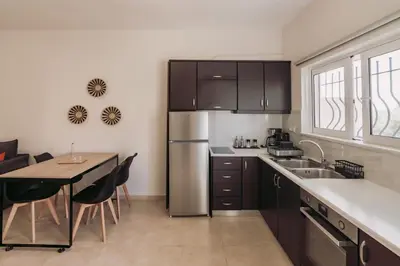 a kitchen with a table and a stainless steel refrigerator at Ibis Apartments Chania,close to the beach in Chania Town