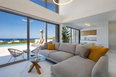 a living room with a couch and a view of the ocean at Theo Luxury Villas With Sea View in Agia Marina Nea Kydonias