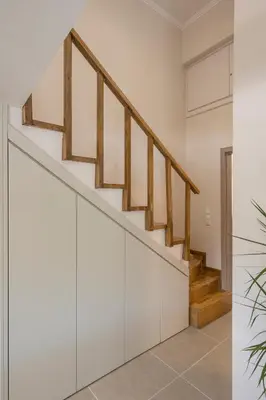 a staircase in a house with white walls and wooden railings at Eranthis Apartment in Chania Town