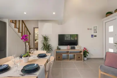 a living room with a table and a television at Eranthis Apartment in Chania Town