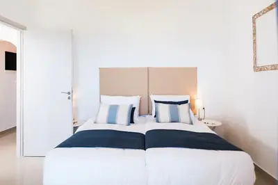 a bedroom with a large bed with blue and white pillows at Villa Alia in Sfakiá