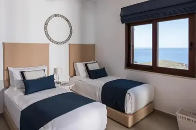 two beds in a room with a view of the ocean at Villa Alia in Sfakiá