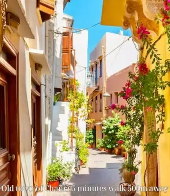 a narrow street with flowers on the side of a building at Hermes Studio - In the city just steps to the sea! in Chania Town