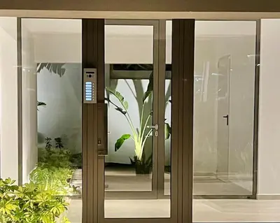 an open glass door of a house with a plant at Hermes Studio - In the city just steps to the sea! in Chania Town