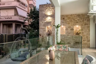 a patio with a table and chairs on a balcony at Newbulit Apartment 1km from the center of Chania in Chania Town