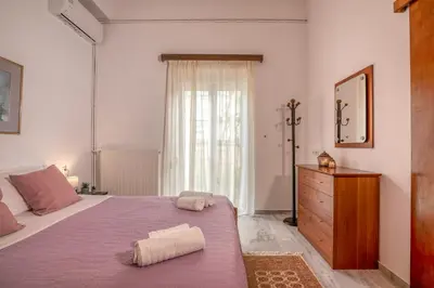 a bedroom with a purple bed and a dresser and a window at Lavande in Chania Town