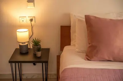 a bedroom with a bed and a table with a lamp at Lavande in Chania Town