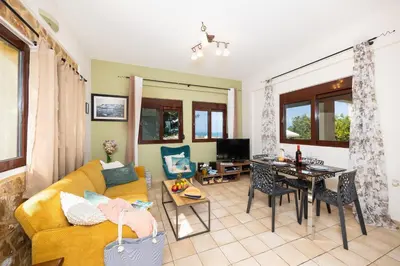 a living room with a yellow couch and a table at Villa Pasiphae 1 in Stalos
