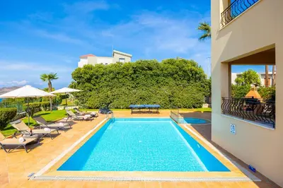 a swimming pool with lounge chairs and a house at Villa Pasiphae 2 in Stalos