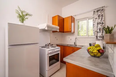 a kitchen with a white refrigerator and a bowl of fruit at Viola Apartment in Kissamos