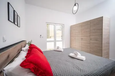 a bedroom with a large bed with red pillows at Viola Apartment in Kissamos