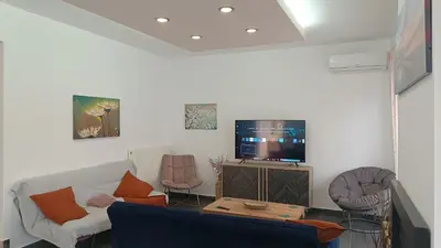 a living room with a couch and a tv at Ammos Family Villa in Daratso