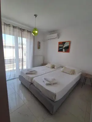 a bedroom with a large bed and a large window at Ammos Family Villa in Daratso
