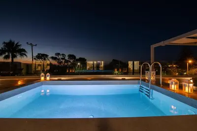 a swimming pool at night with a view at Casa Platanias Bridge in Plataniás