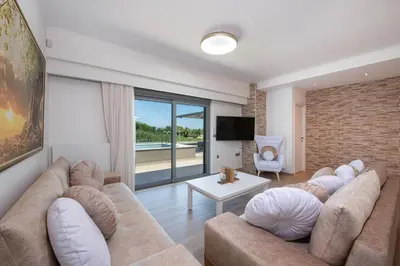 a living room with a large couch and a television at Casa Platanias Bridge in Plataniás