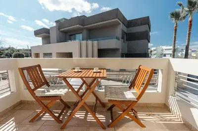 a table and two chairs on a balcony at El Chacha Apartment in Galatás