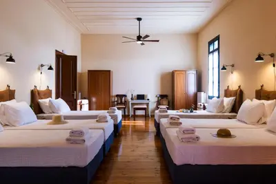 a room with four beds with towels on them at Sundial Lodge in Chania Town