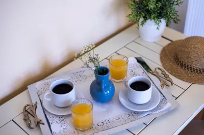 a tray with cups of coffee and glasses of orange juice at Sundial Lodge in Chania Town