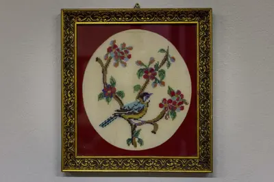 a framed picture of a blue bird on a tree branch at Sundial Lodge in Chania Town