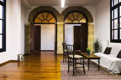 a room with a bed and a table and chairs at Sundial Lodge in Chania Town