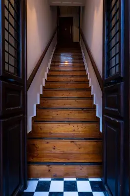 a staircase in an old house with a checkered floor at Sundial Lodge in Chania Town