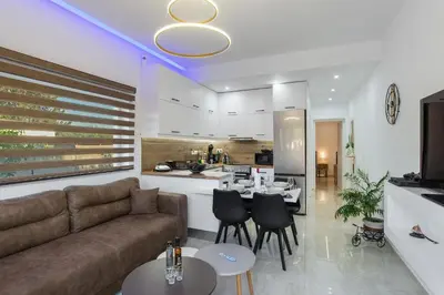 a living room with a couch and a kitchen at Casa Manou - Kalyves beach in Kalyves