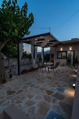 a patio with a table and chairs under a roof at Casa Manou - Kalyves beach in Kalyves