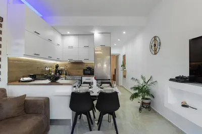 a kitchen and living room with a table and chairs at Casa Manou - Kalyves beach in Kalyves
