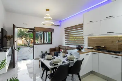 a kitchen and dining room with a table and chairs at Casa Manou - Kalyves beach in Kalyves