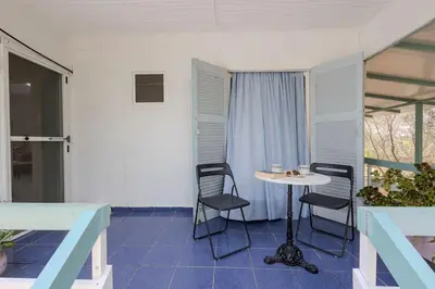 a patio with a table and chairs in a room at Rastoni - Beach Family House in Chorafakia